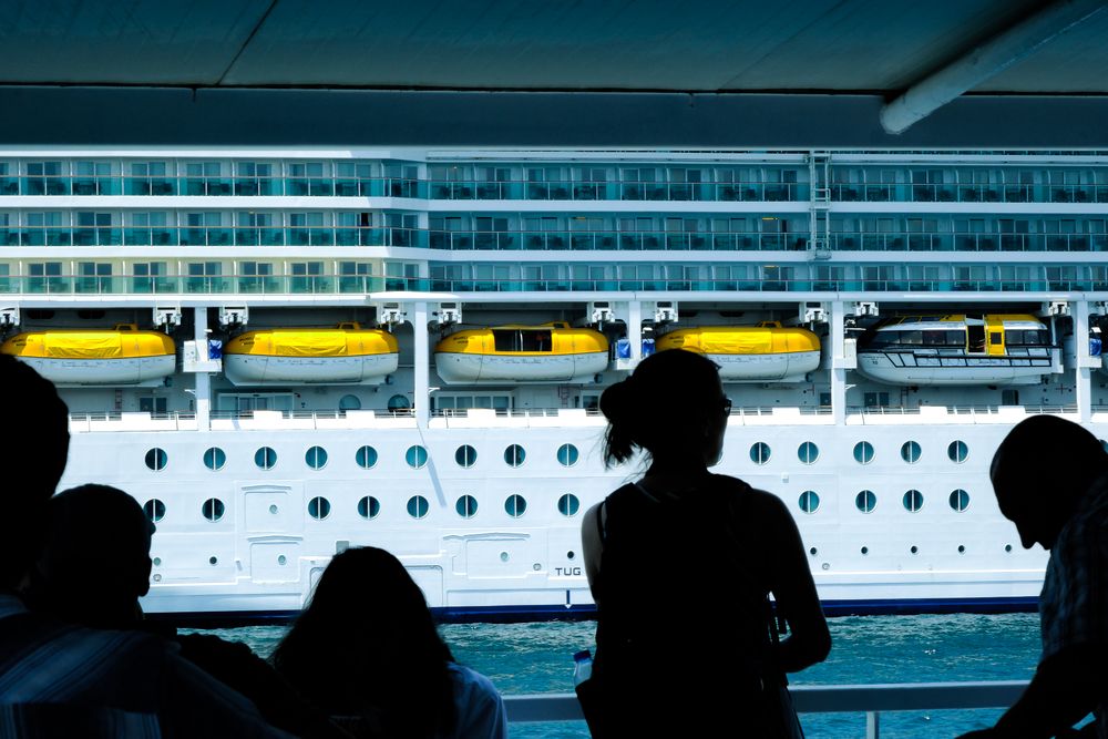 Pessoas observando um navio de cruzeiro atracado no porto